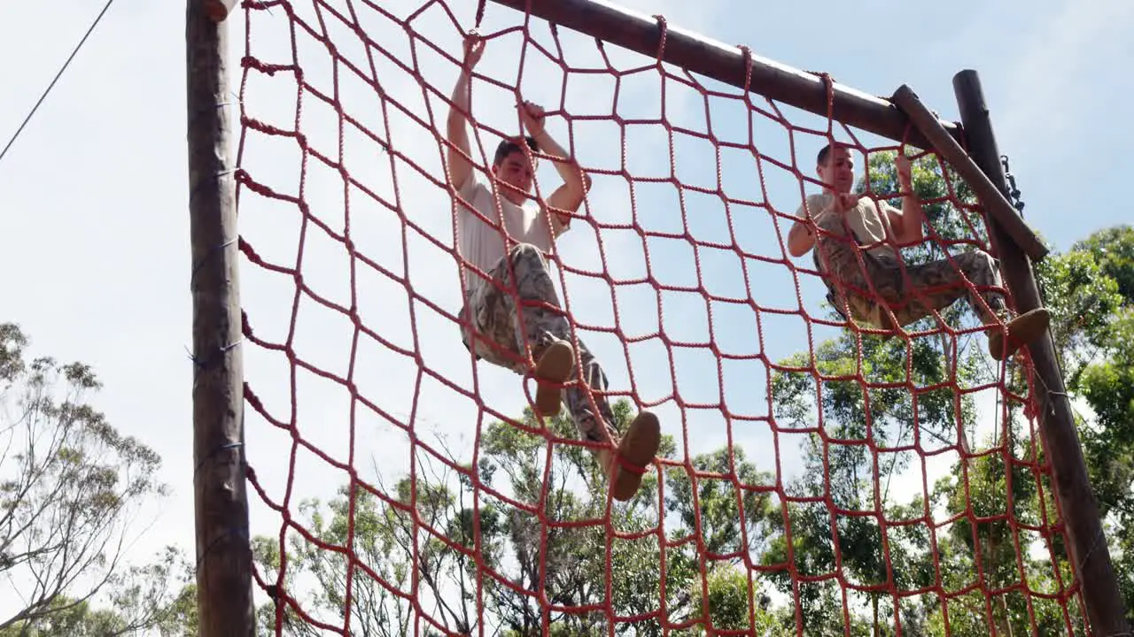 Military troops climbing a net during obstacle course 4k