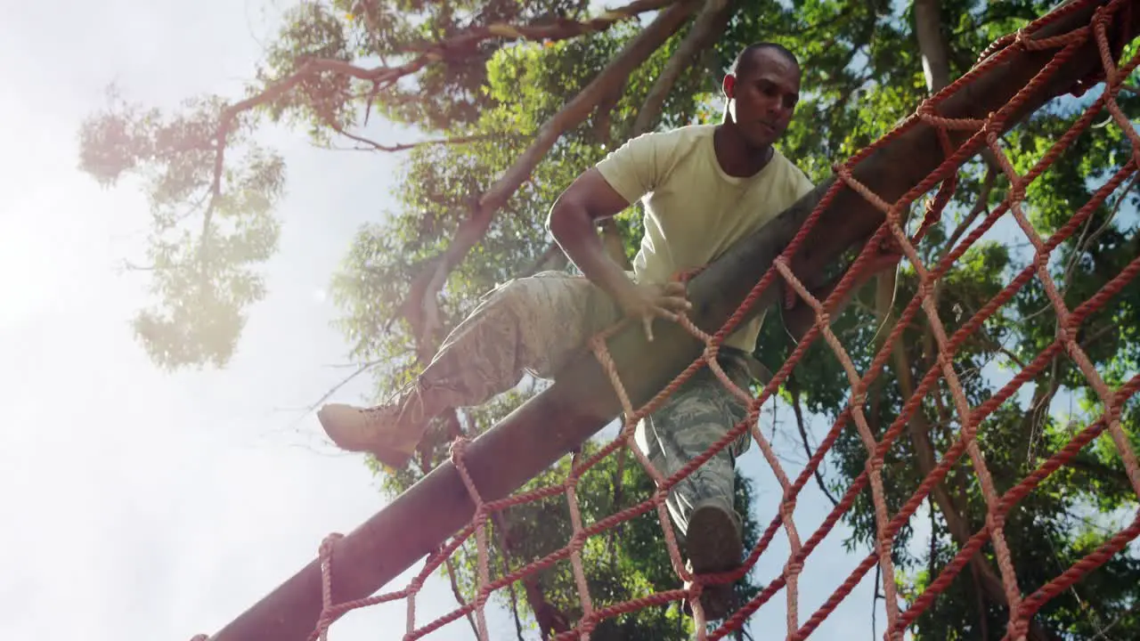 Military soldier climbing a net during obstacle course 4k