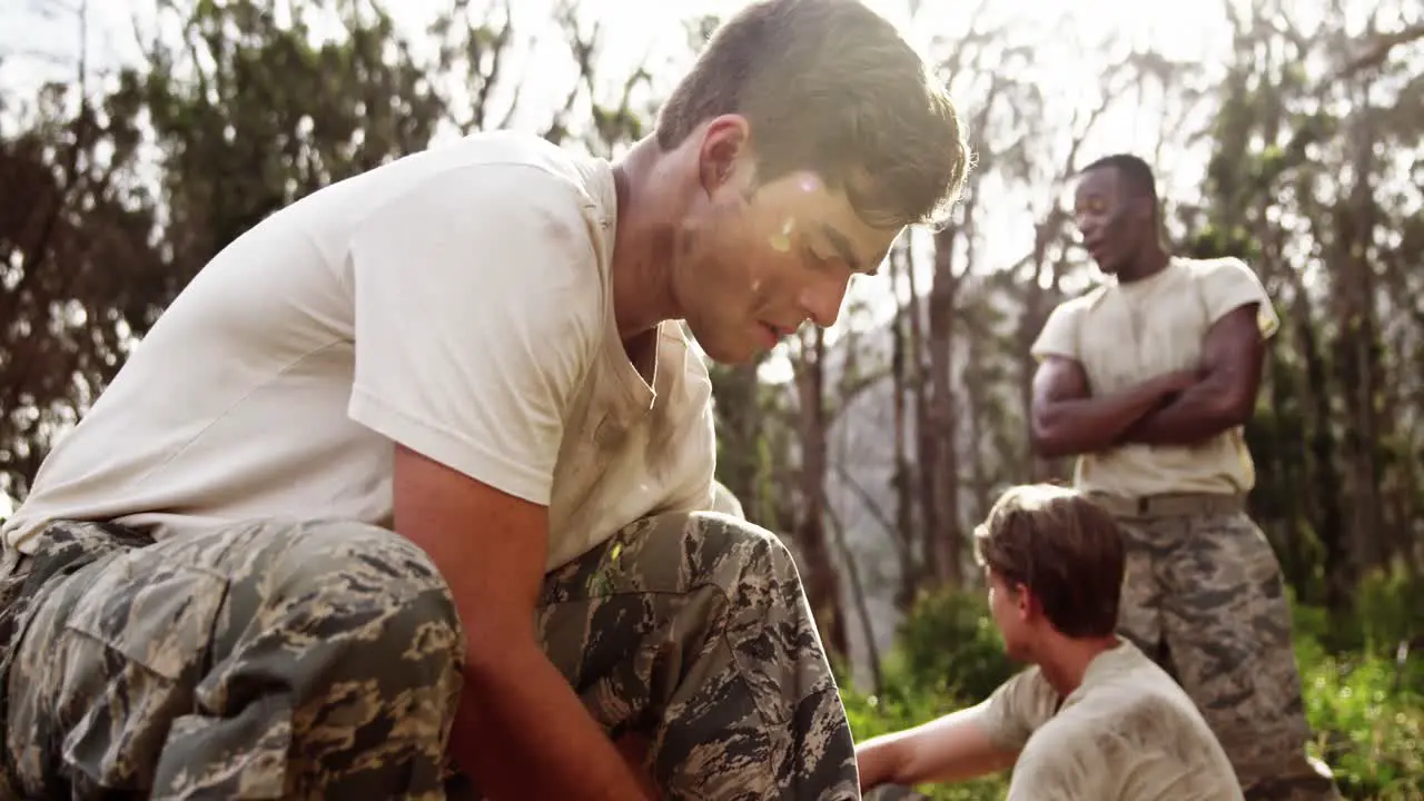 Military soldier tying shoelaces at boot camp 4k