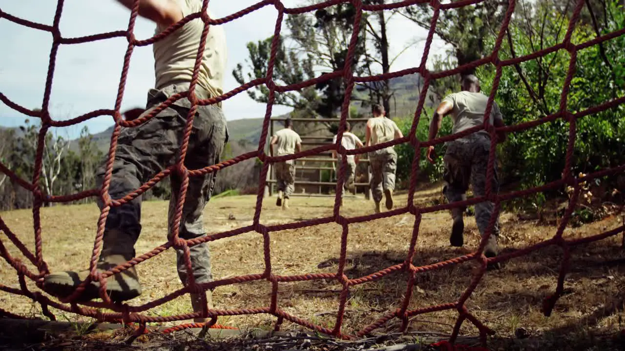 Military troops running during obstacle course 4k