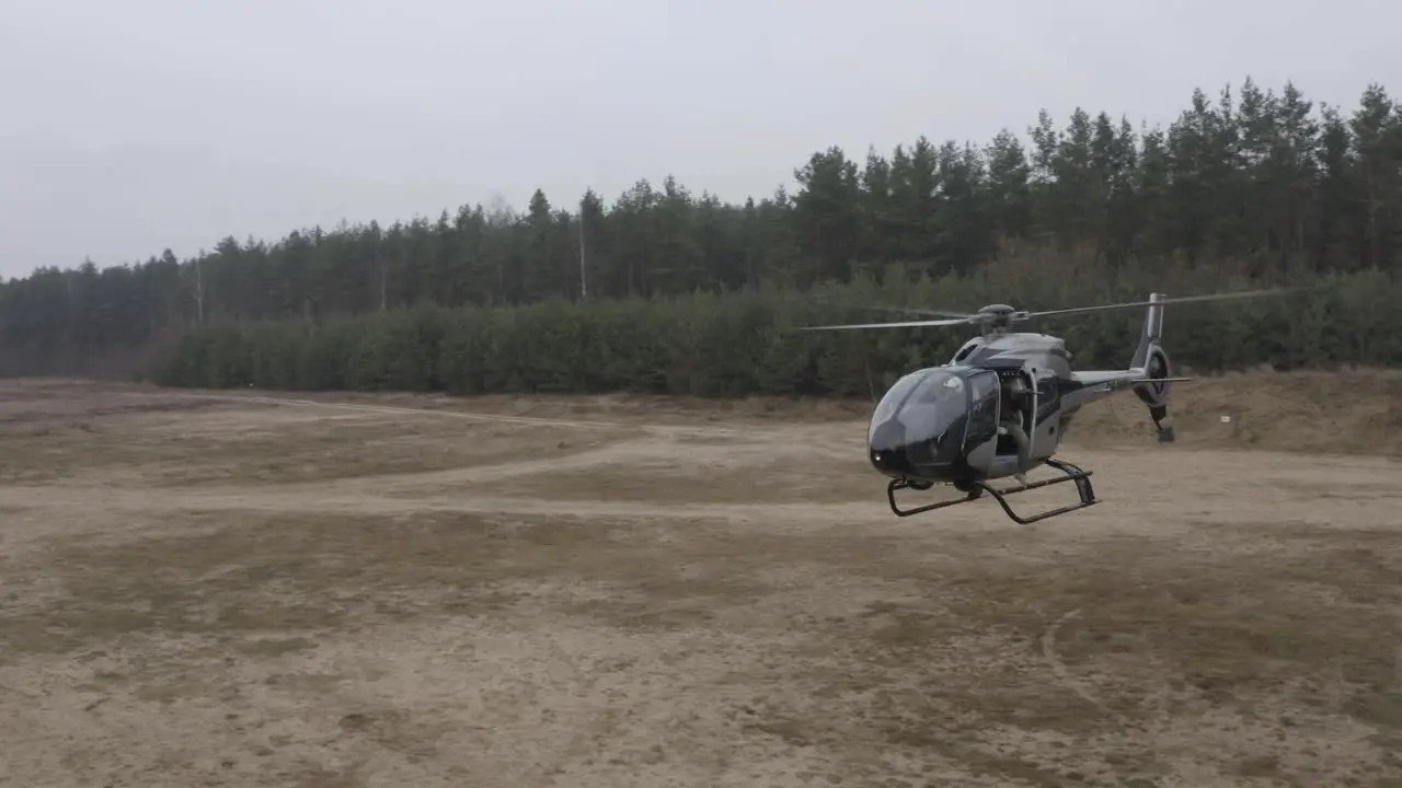 Aerial View of Military Helicopter Flying Above Training Field Drone Shot