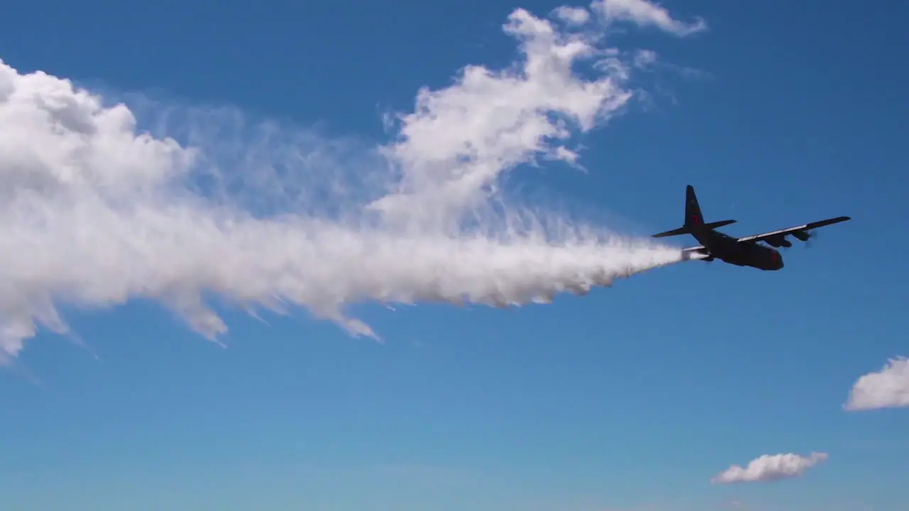 An C130 Aerial Tanker Drops Fire Retardant And Water Near A Fire Zone 1