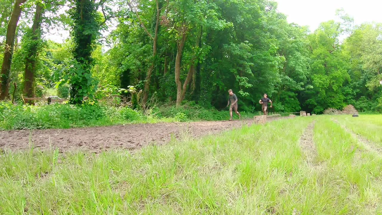 Fit men training over obstacle course 4k