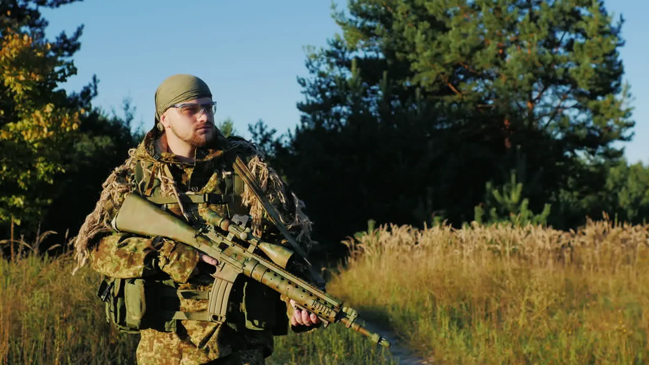 A Man In A Camouflage Bandanna And Walking Along A Country Road In The Hands Holding Weapons Slow Mo