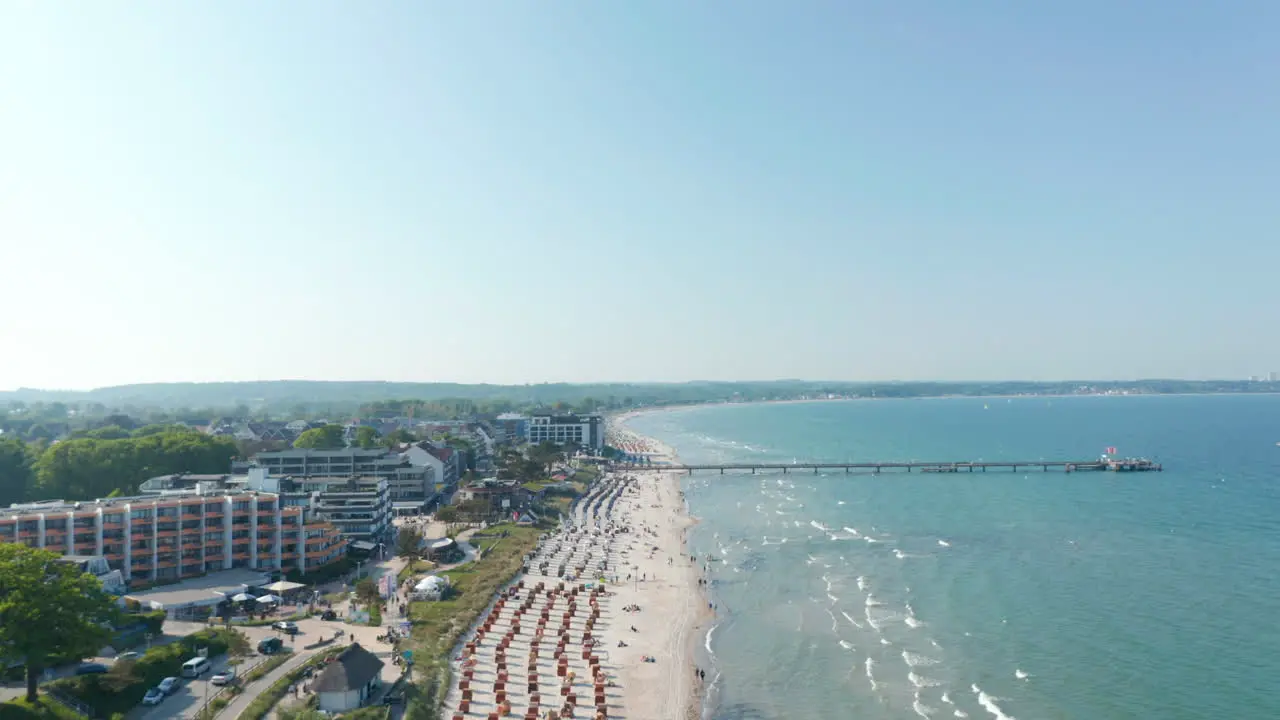 Aerial view of beach tourist destination coastline on sunny day Baltic sea Scharbeutz Germany dolly in