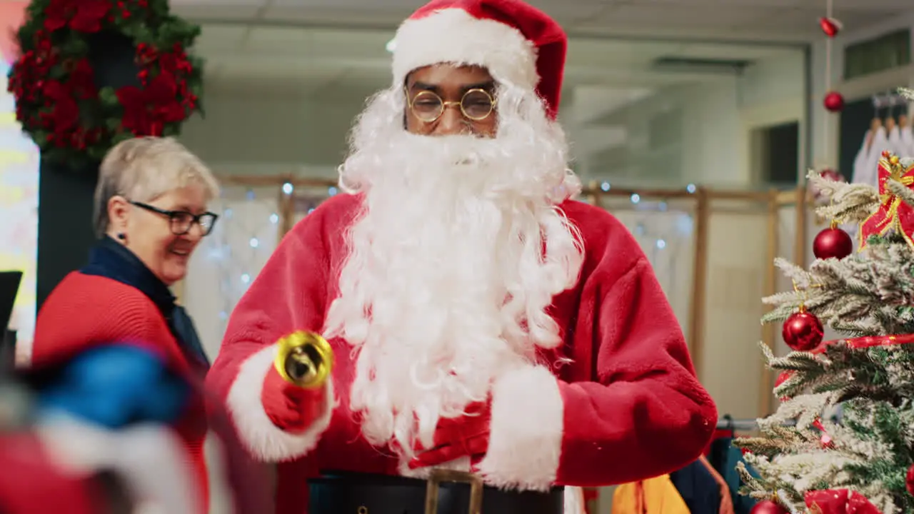 Worker dressed as Santa Claus entertaining shoppers in xmas adorn fashion store during winter holiday season Retail assistant sharing festive spirit with customers visiting clothing shop