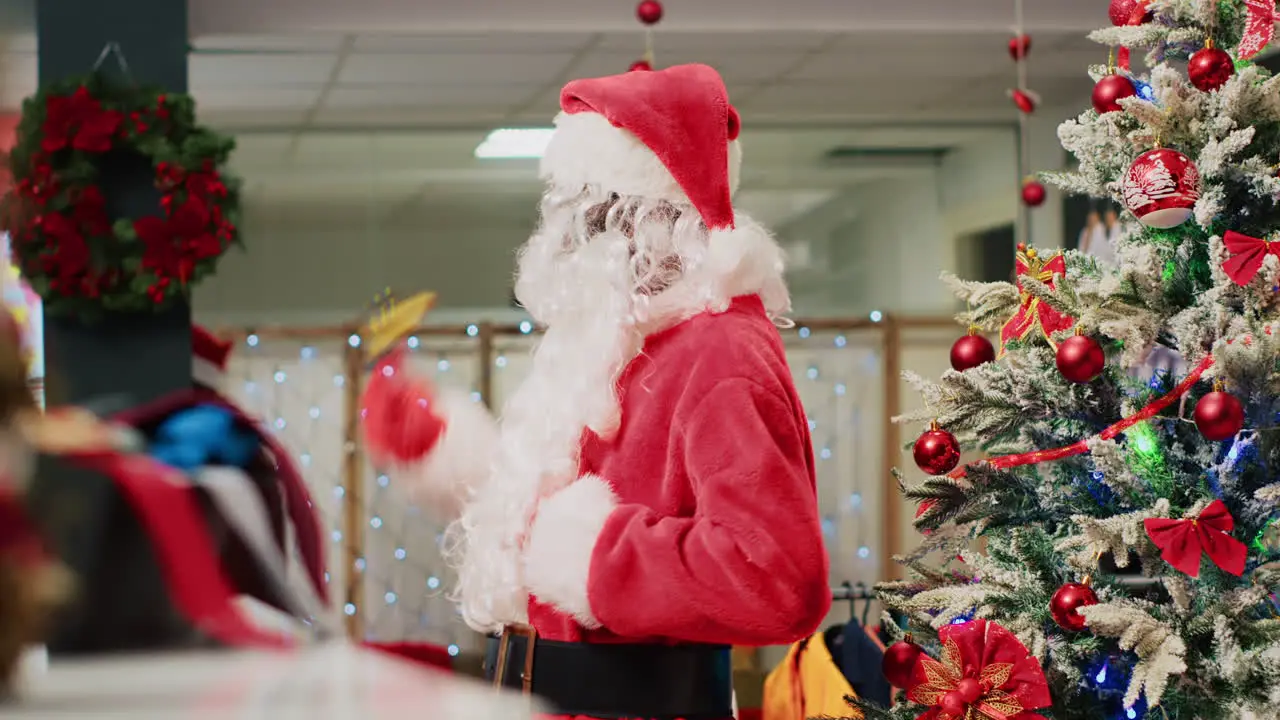 Employee acting as Santa Claus entertaining shoppers in Christmas decorated fashion store during winter holiday season Worker instilling festive spirit in clients visiting clothing shop