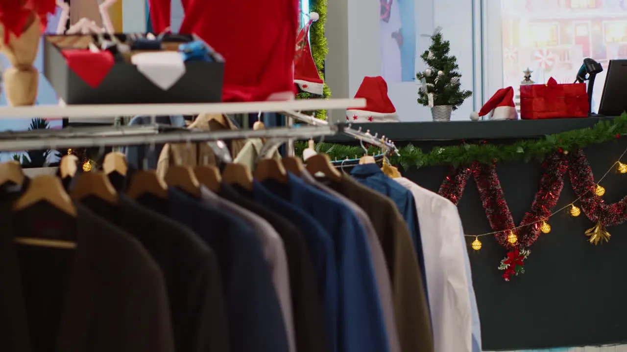 Rack of formal attire shirts in empty Christmas decorated clothing store waiting for customers looking for presents during winter holiday season Blazers in xmas adorn fashion boutique