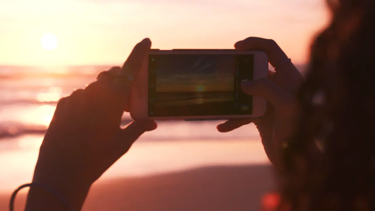 Hands phone and woman at the beach at sunset