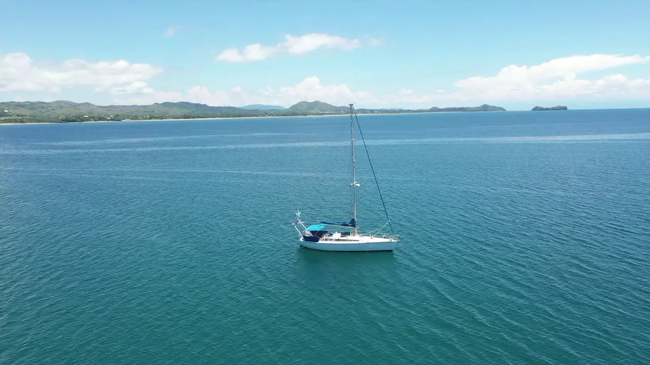 rotating aerial shot of a sail boat in a blue ocean off the coast of Madagascar