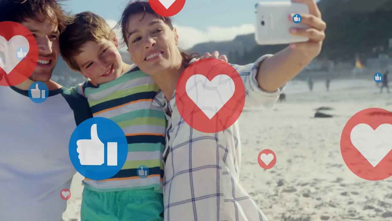 Animation of hearts over happy caucasian family taking photo on beach