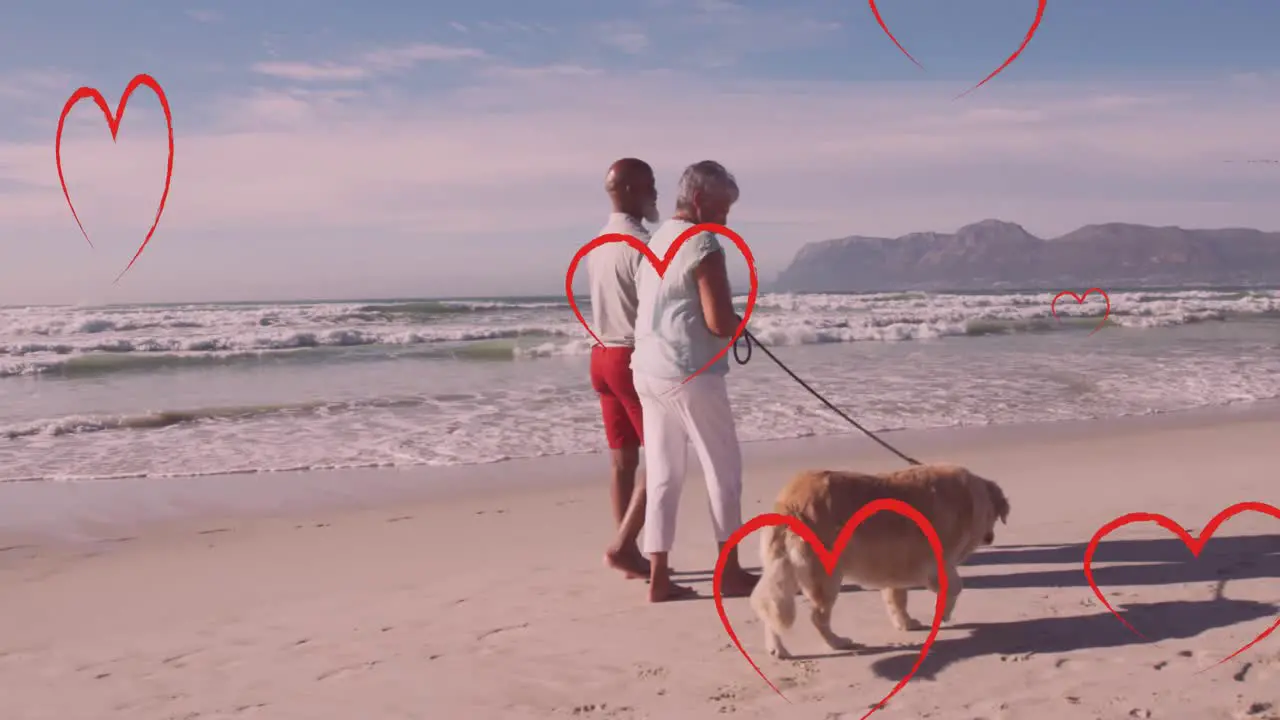 Animation of hearts over senior african american couple with dog on sunny beach