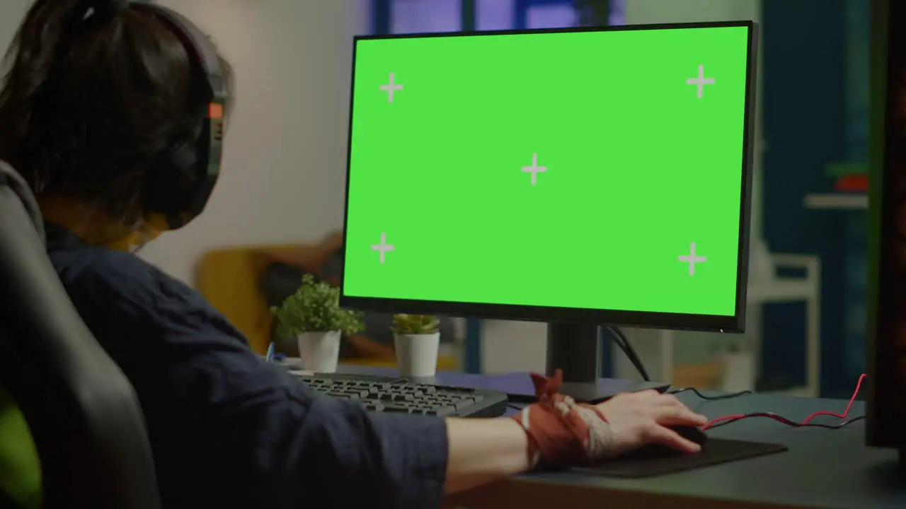 Woman streaming online video games on powerful computer with green screen