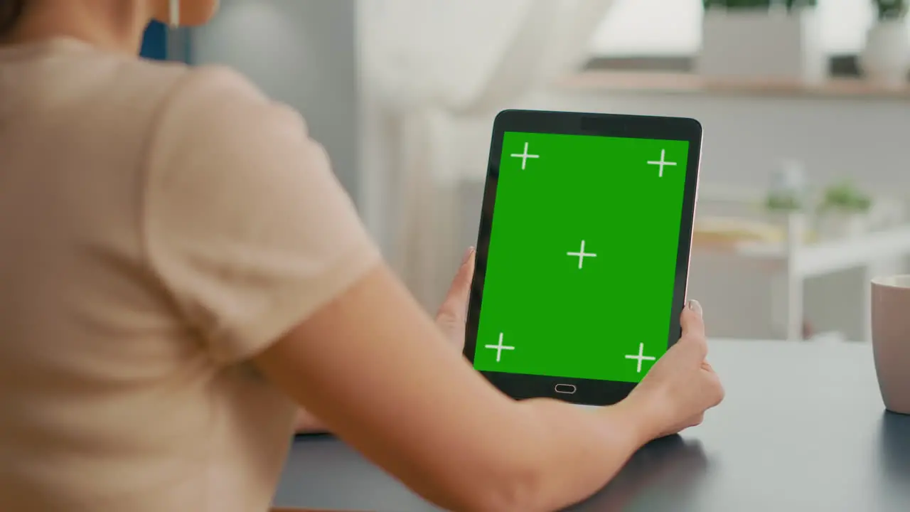 Freelancer woman holding tablet computer with mock up green screen