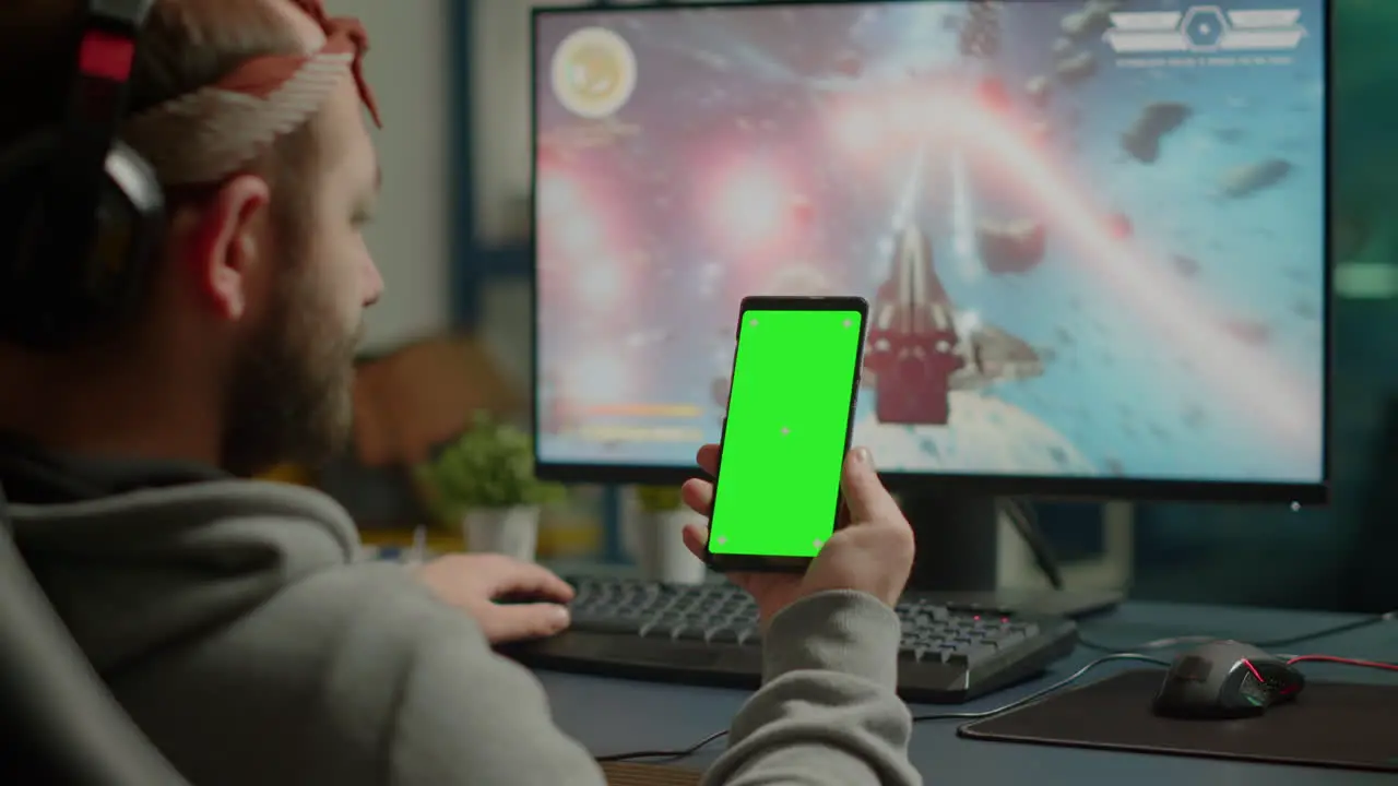 Concentrate gamer holding phone with mock up display