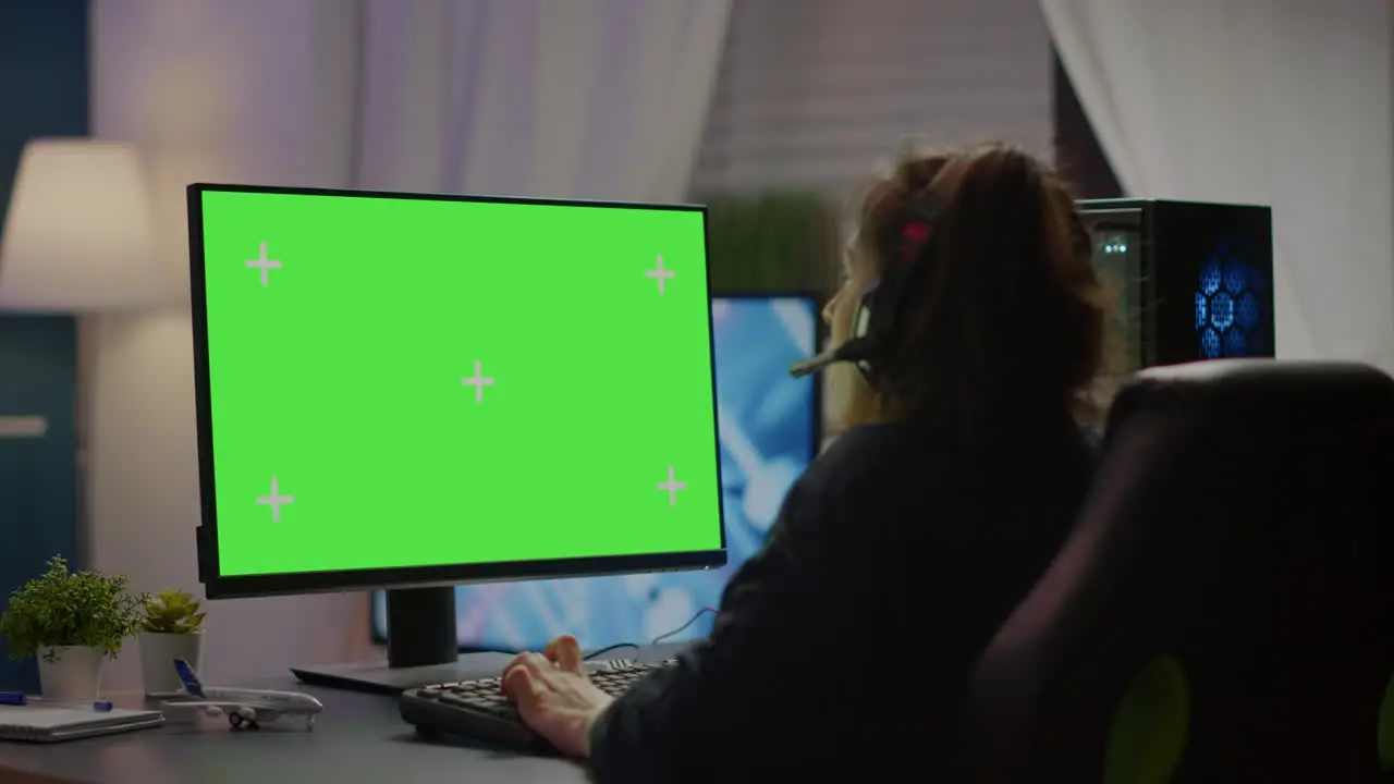 Pro gamer playing virtual video game on computer with green screen