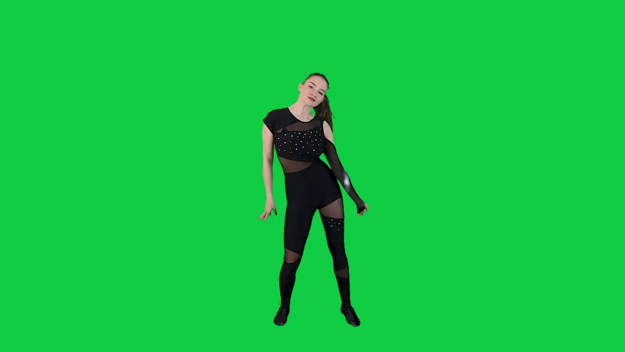 Stunning female dancer performing a dance in front of a green screen wearing a black outfit in slow motion