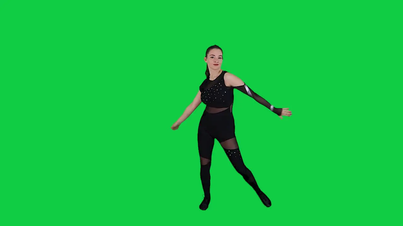 Skilled and expressive female dancer dancing in front of a green screen wearing black full body suit slow motion