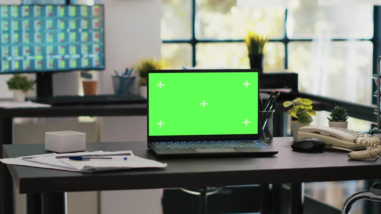 Mockup laptop on company desk with computer desktop showing stock exchange