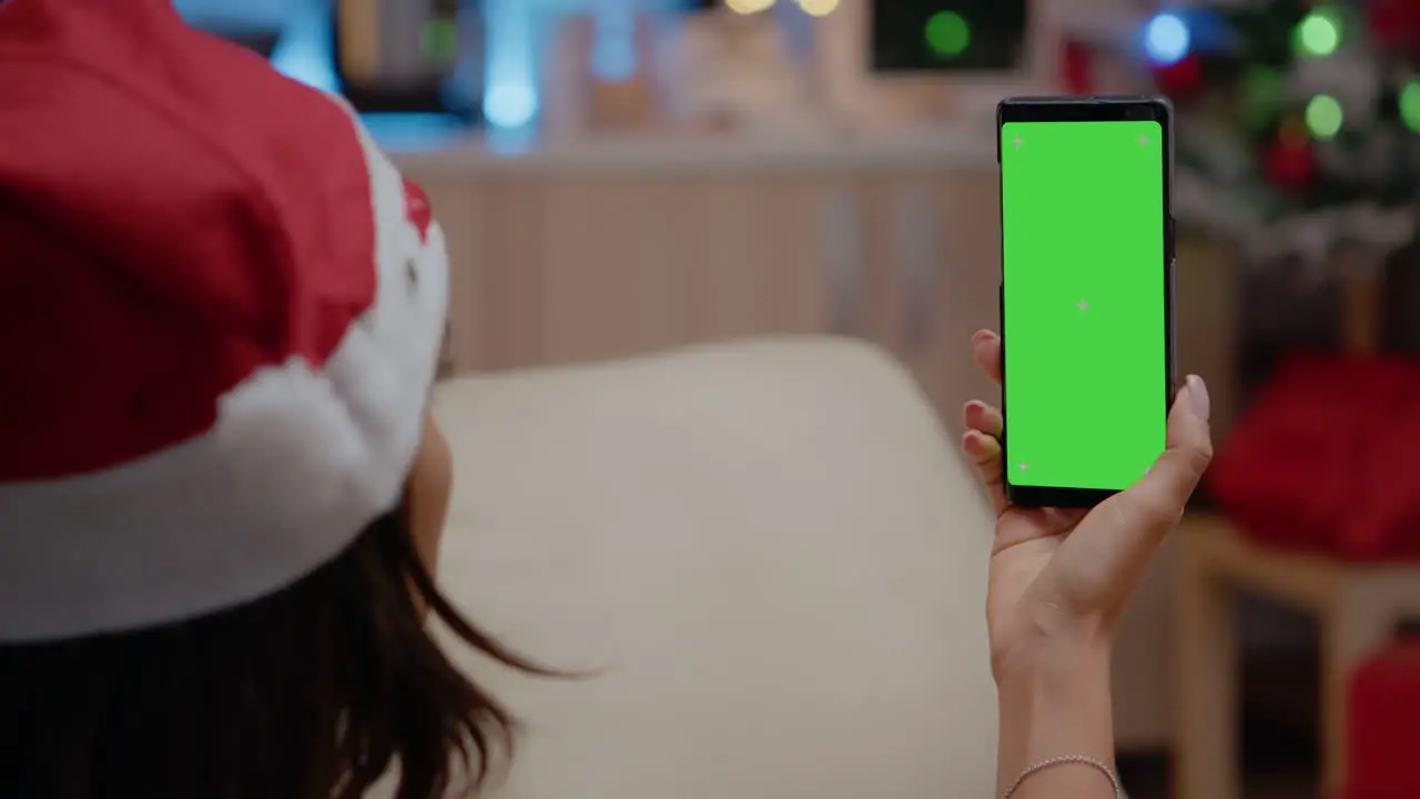 Close up of adult vertically holding smartphone with green screen