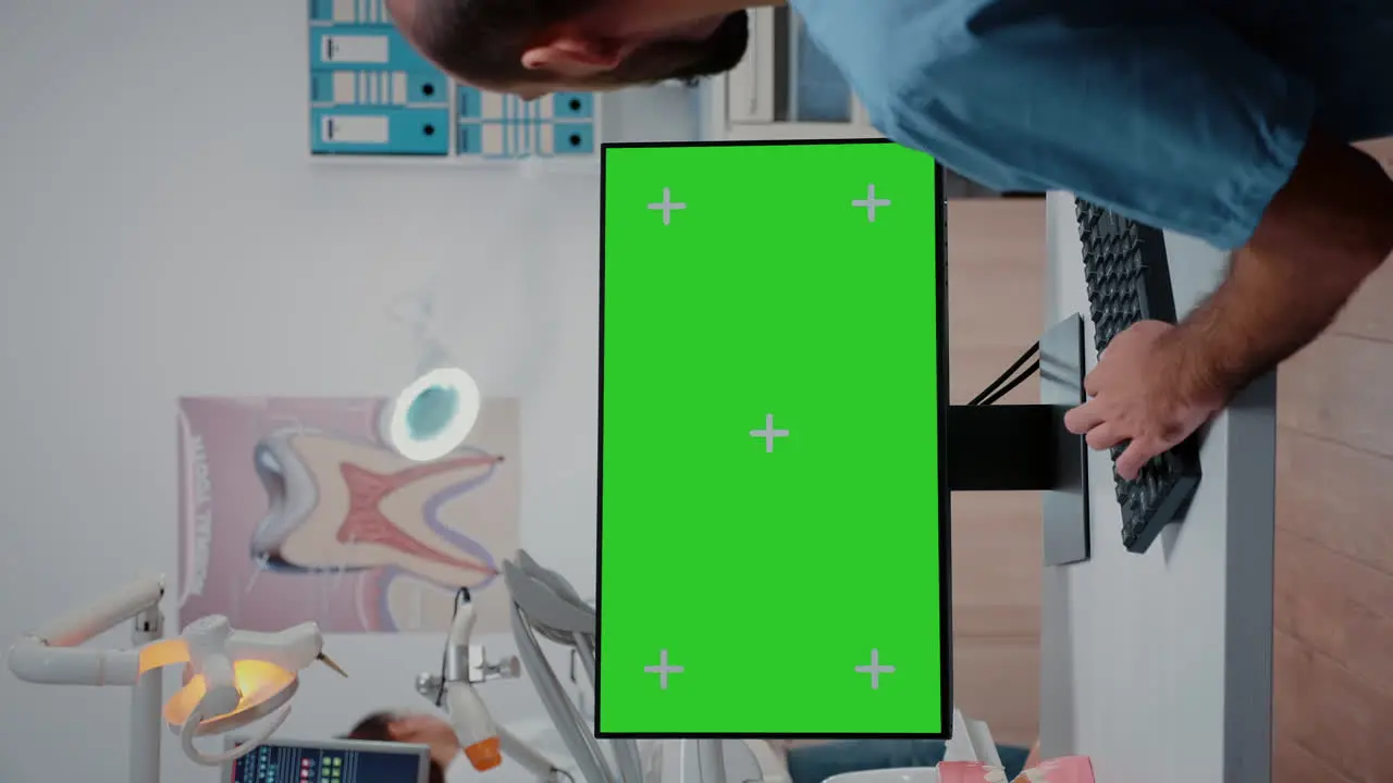 Vertical video Man nurse working with keyboard and monitor