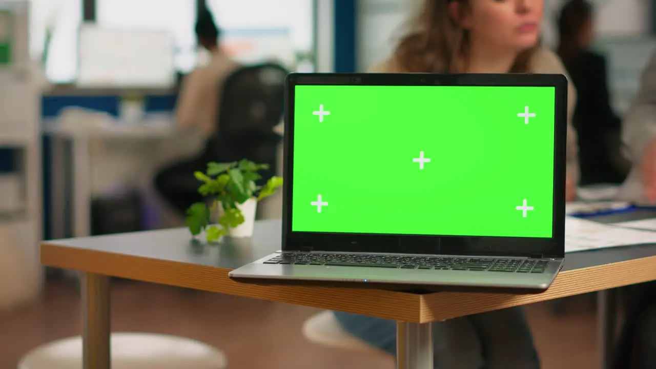 Businesspeople analysing financial reports sitting in back of laptop with green screen