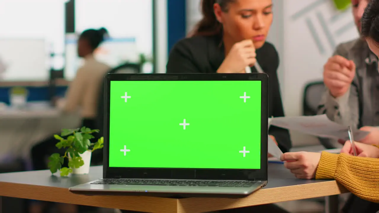 Laptop with green screen ready for presentation placed on desk