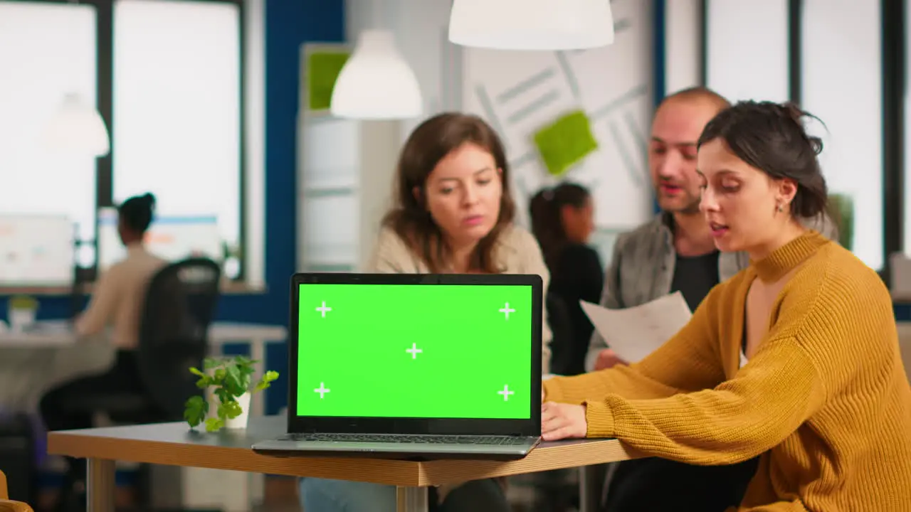 Group of business people discussing company plan with mockup laptop