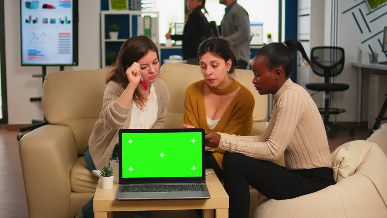 International business team talking in back of mockup laptop