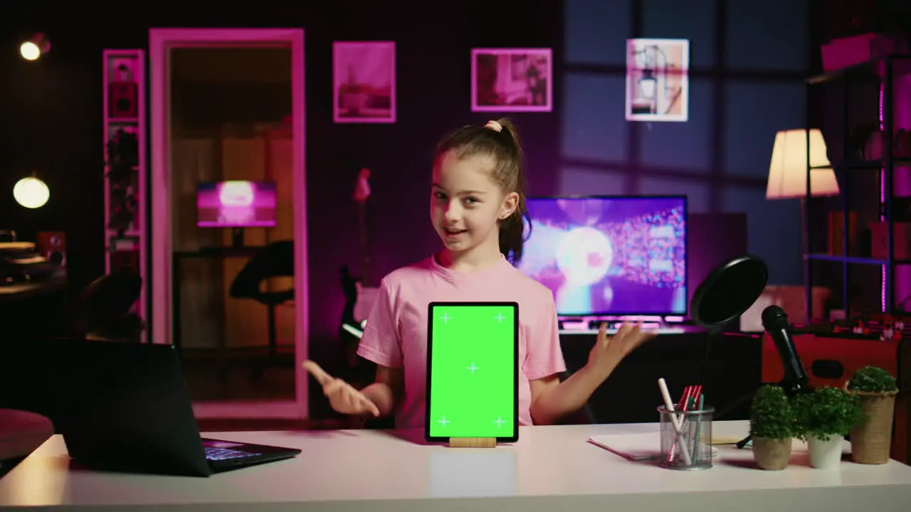 Cute kid filming internet show promoting green screen tablet received from sponsoring brand