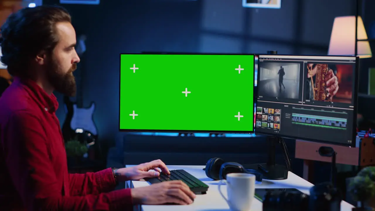 Videographer uses editing software on green screen computer to assemble footage