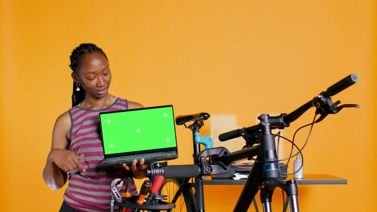 Mechanic promoting bicycle fixing service with chroma key laptop