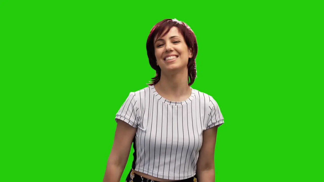 Portrait of adorable woman posing on green screen showing call me gesture with hand