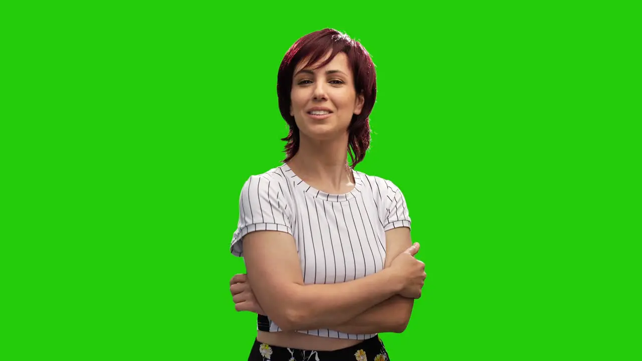 Cheerful short haired brunette woman crossing hands and posing in green screen