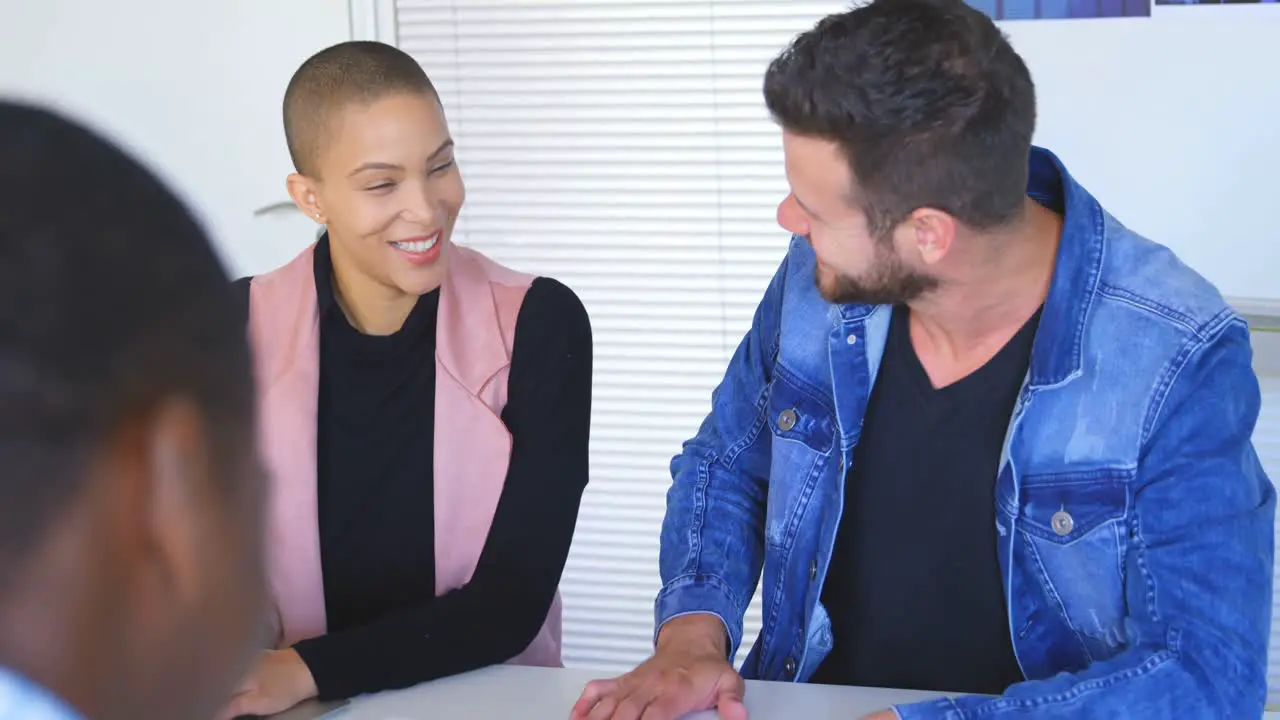 Front view of young caucasian business colleagues interacting with each other in office 4k