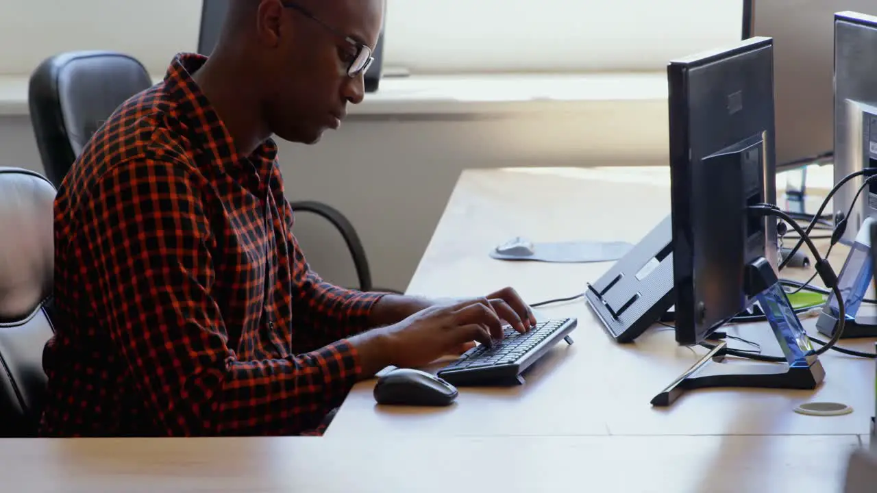 Side view of young black businessman working at desk in a modern office 4k