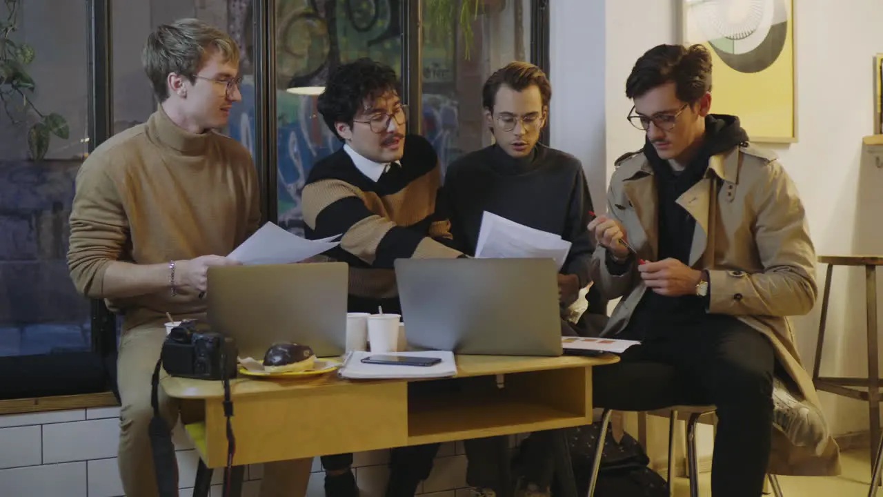 Businessmen reading documents in cafe Male partners discussing business papers