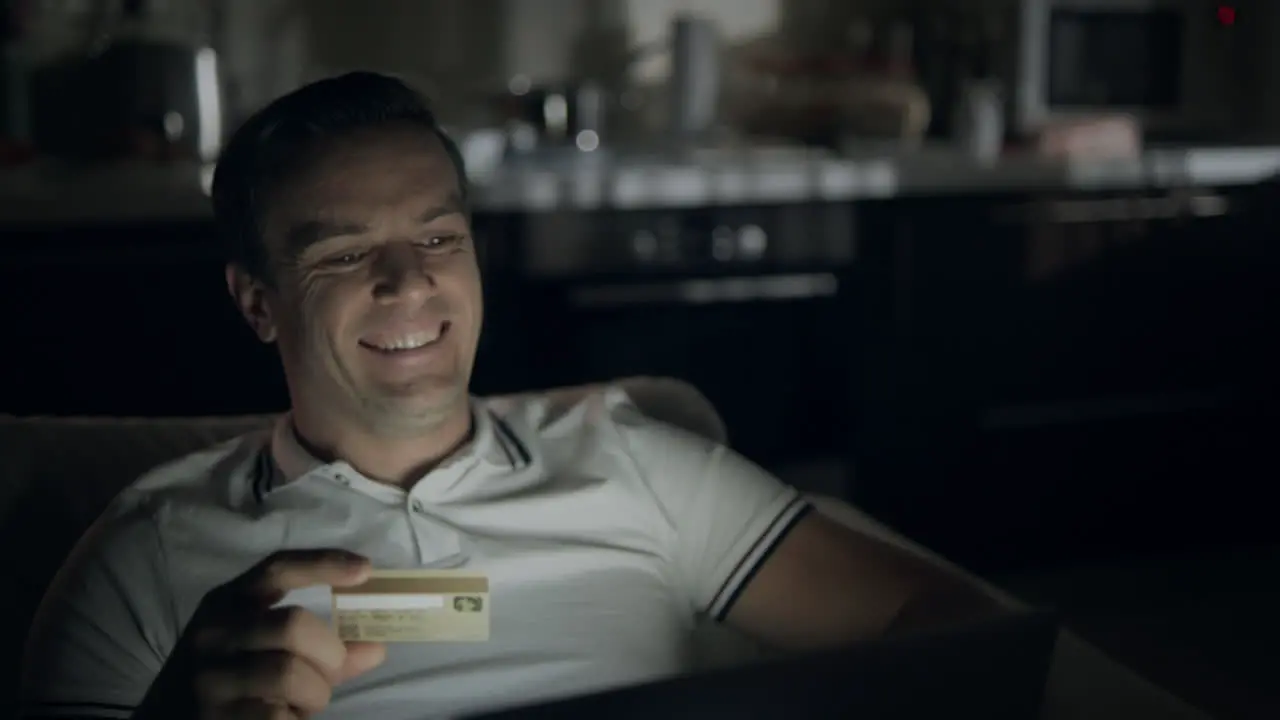 Happy businessman making online shopping at night time