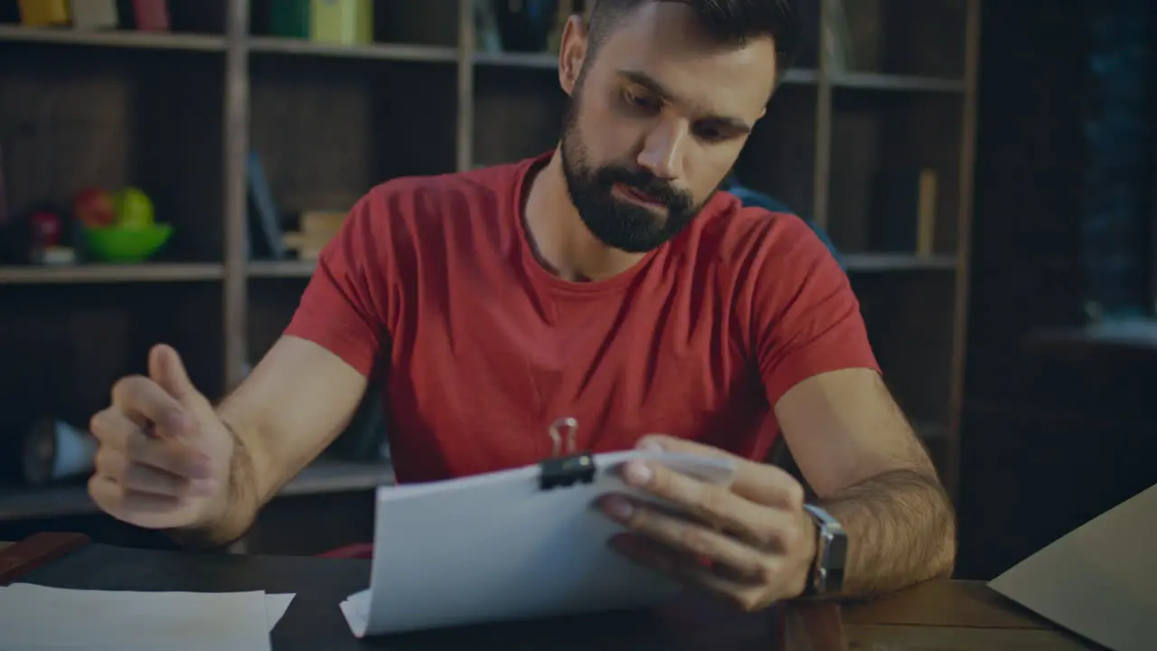 Young business man reading documents in office Paperwork in office at evening