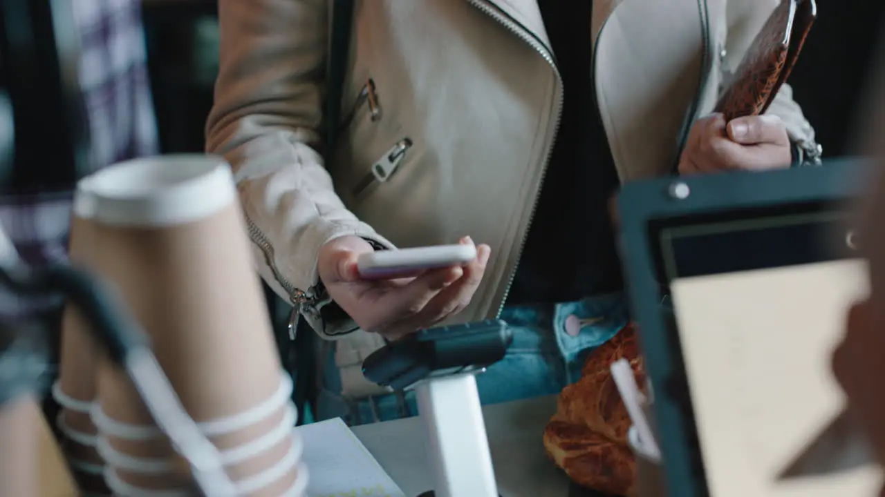 beautiful asian woman making contactless payment using smartphone mobile money transfer buying coffee in cafe enjoying service at restaurant