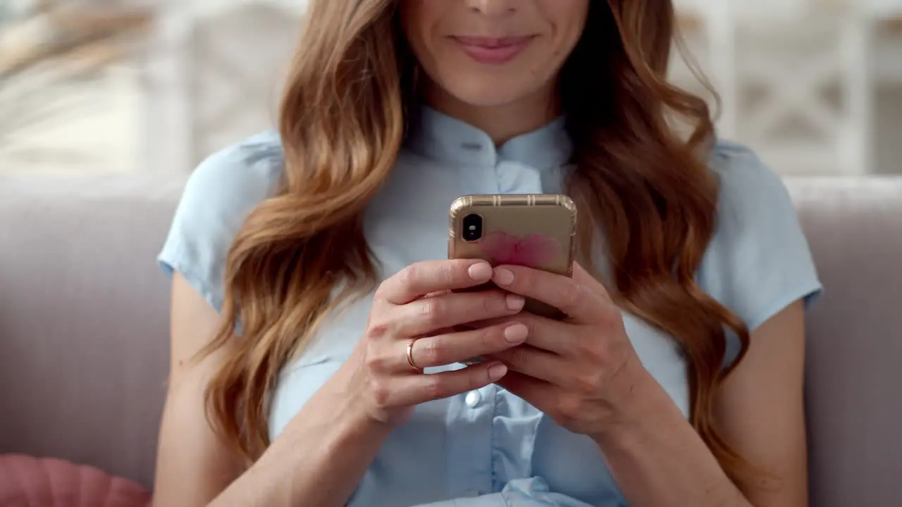 Business woman hands typing message on mobile phone at home office