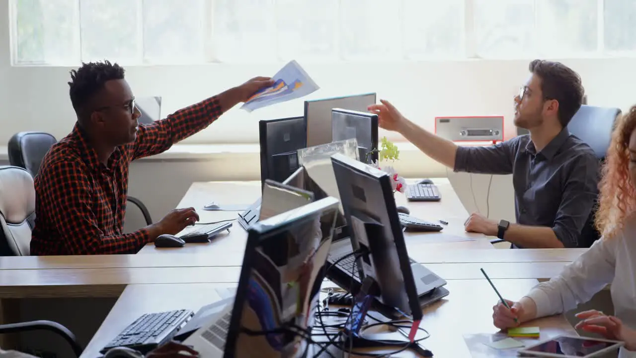 Side view of young cool mixed-race business team working at desk in a modern office 4k