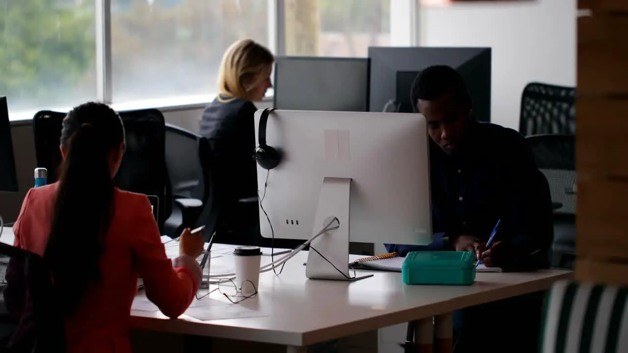 Business colleagues working together on desk in office 4k