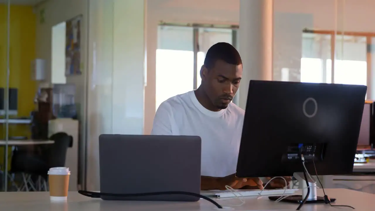 Young male executive working on computer at desk in modern office 4k