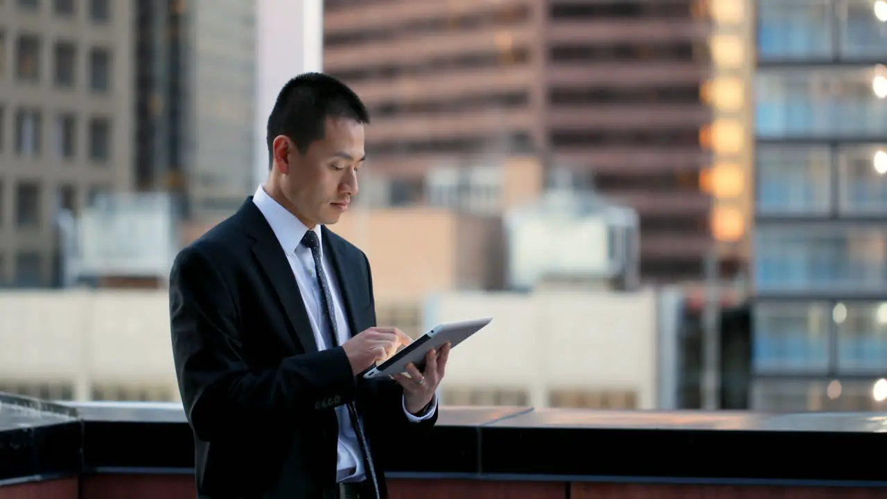 Side view of young Asian Businessman working on digital tablet 4k