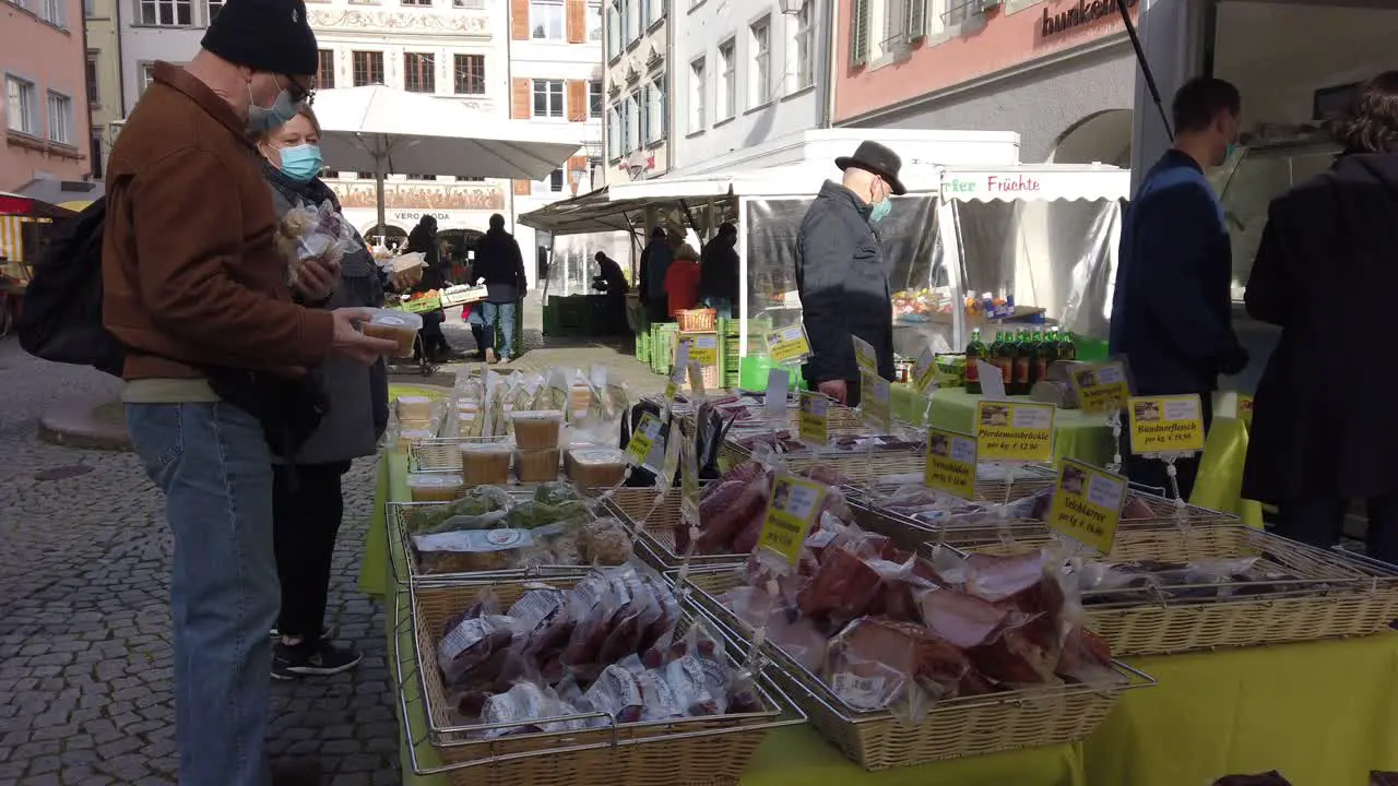 street market display with man buying sausages and dry prcessed meat in Feldkirch Austria