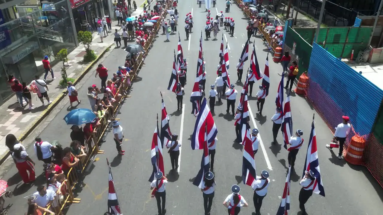 Drone Shot Following School Children Hoisting Costa Rican Flag During Independence Day Parade