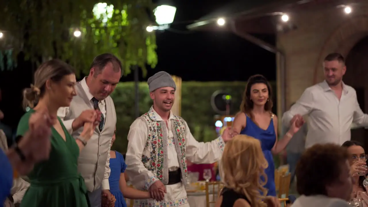 People dance traditional dance at a wedding party in Romania