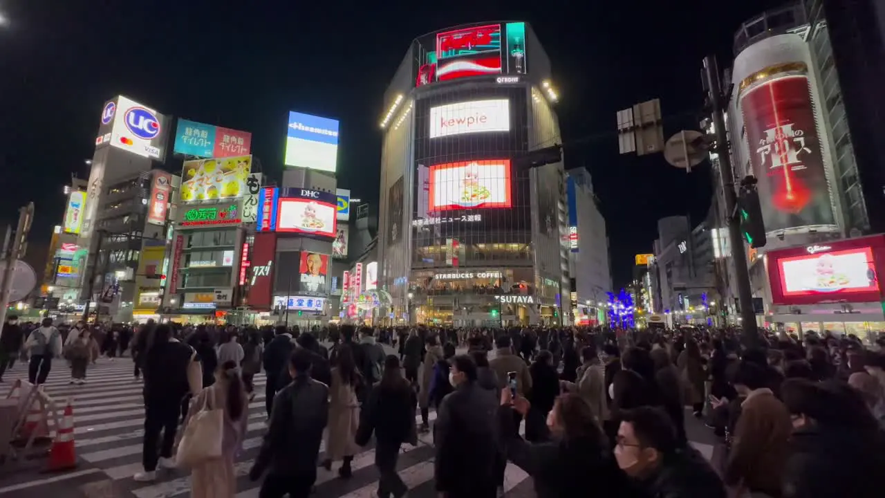 pedestrians crowds crossing Shibuya road intersection Tokyo Japan