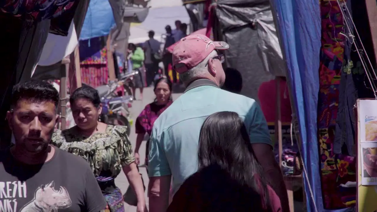 Old man gringo walking through Chichi market in Guatemala uring daytime